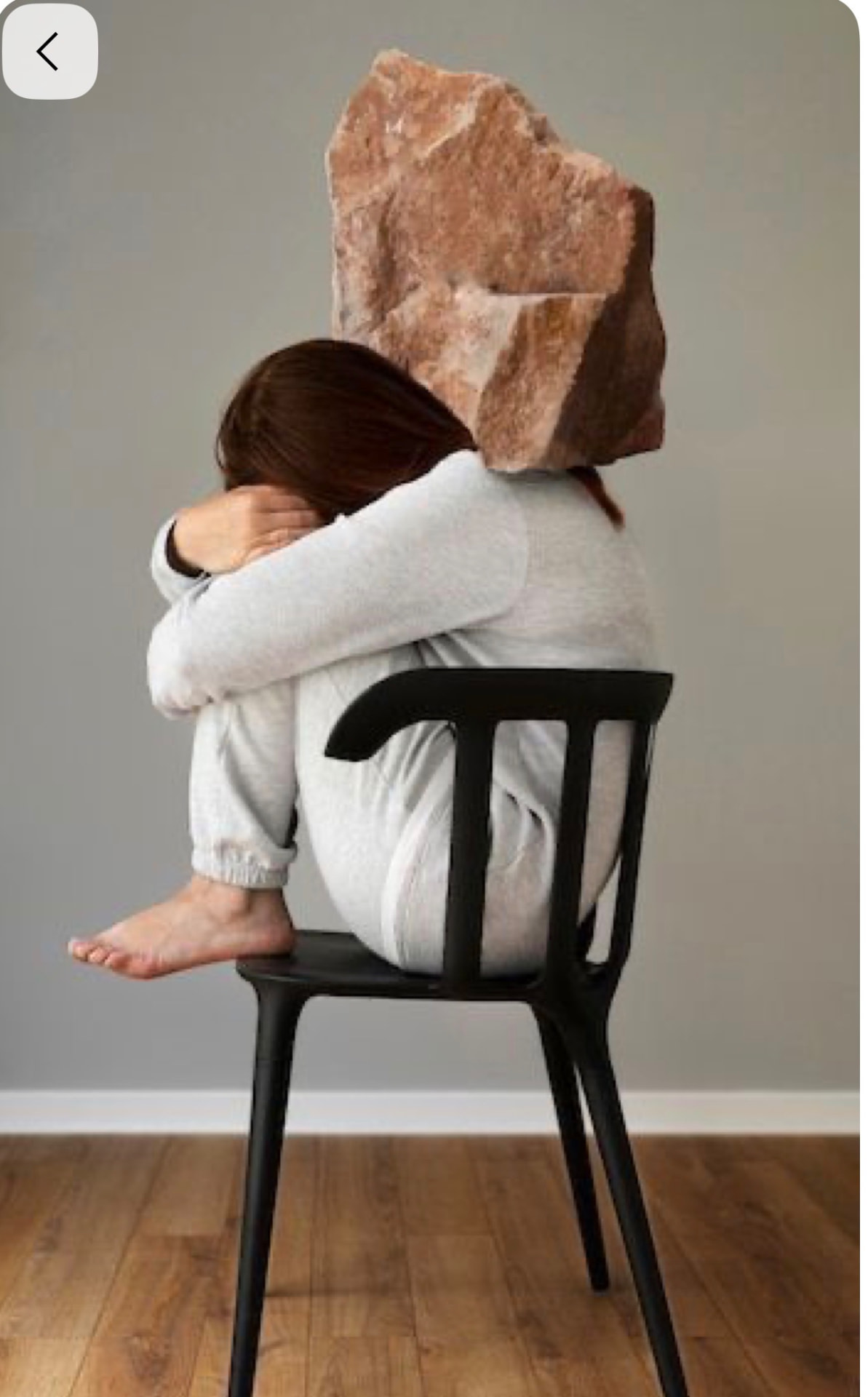 Femme assise sur une chaise, un grand rocher posé sur ses épaules — métaphore du poids émotionnel